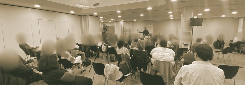 Sala de formación del Instituto Área Zentro durante una clase presencial: el grupo de alumnos sentado y el profesor de pie al fondo